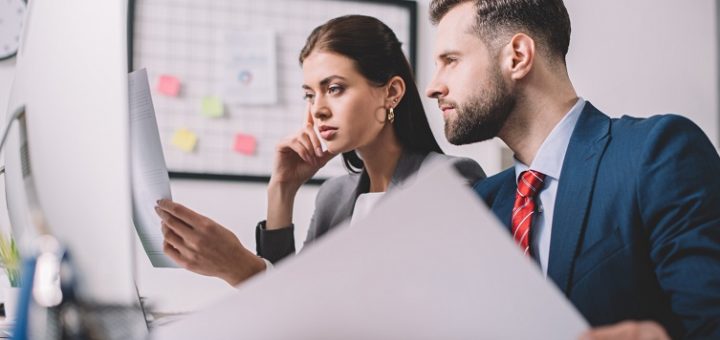 Moderne Beratungsfirma mit diversen Beratern, die in einem Büro mit Glaswänden und zeitgenössischem Mobiliar arbeiten.